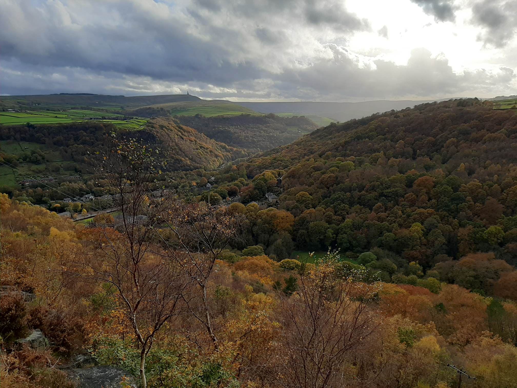 Autumnal woods above Hebden Bridge, with the Stoodley Pike monument in the distance